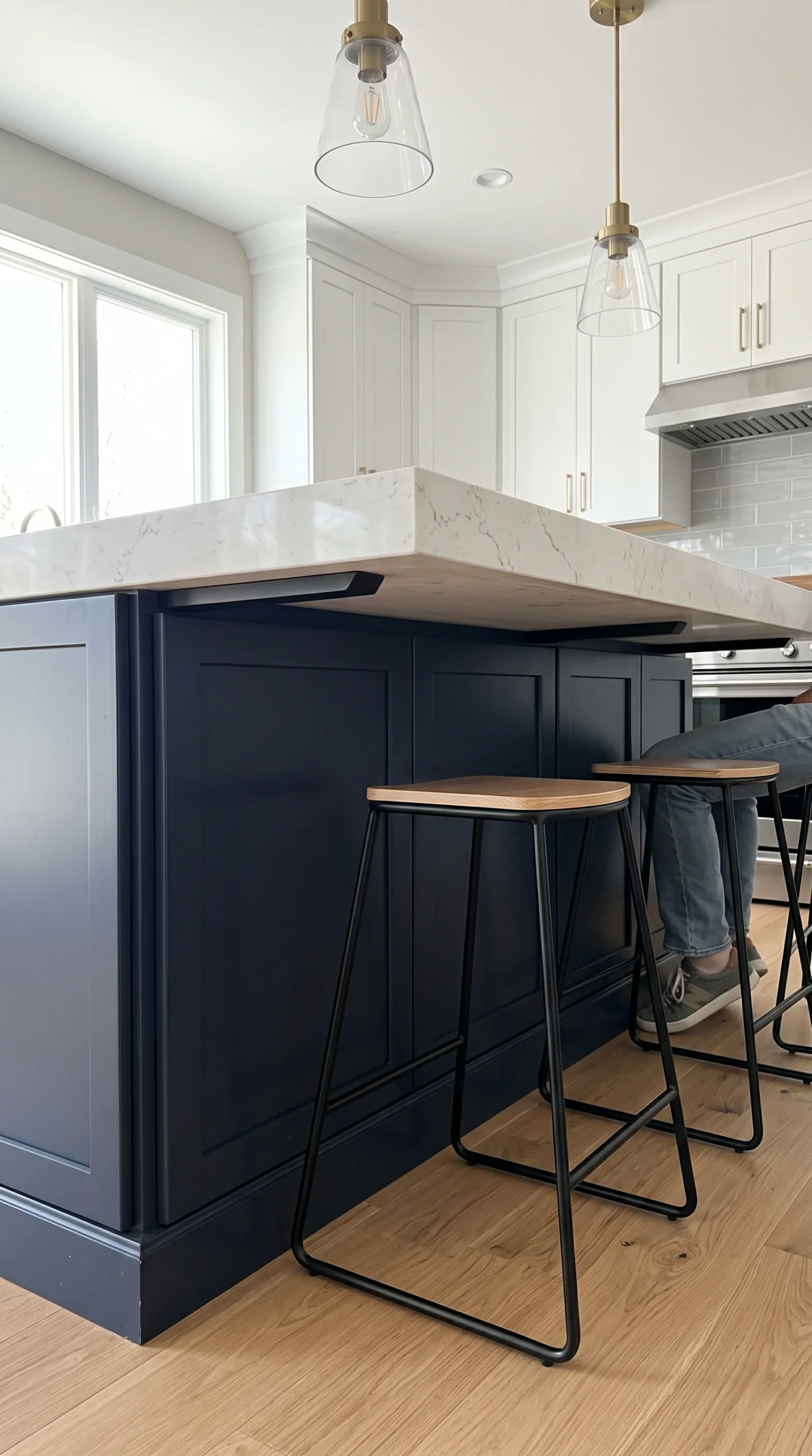 Kitchen island ideas with seating: a deep white stone countertop with extensive knee room.